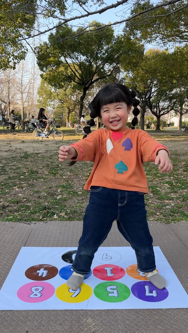 屋外でBrain Step のシートの上に立ち、笑顔でステップする女の子