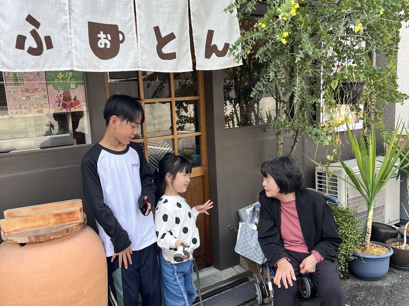 おふとんハウスの外観。のれんのかかった入口に参加者が来られているところ